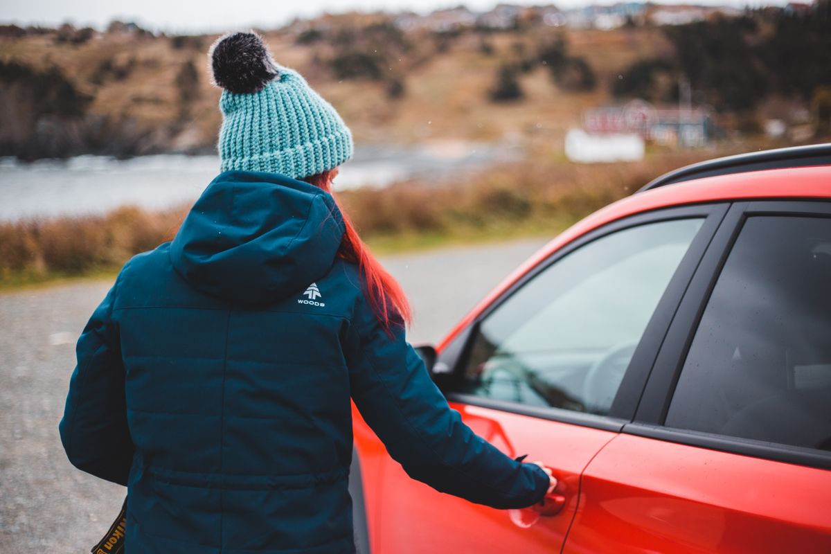 Person opening the door of their car in a parking area